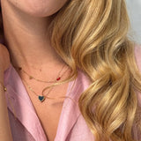 Gold necklace with a black on one side and red on one side pendant