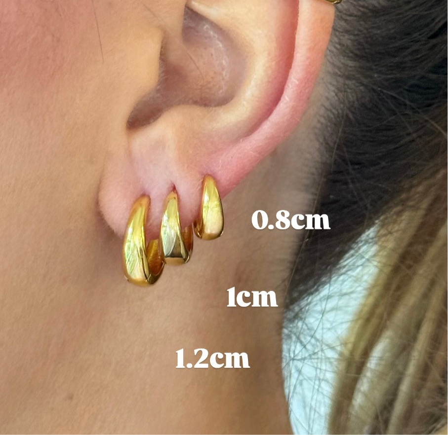 Gold hoop earrings displayed on an ear with size measurements.