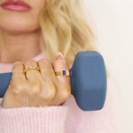Person holding a blue dumbbell with a blurred background