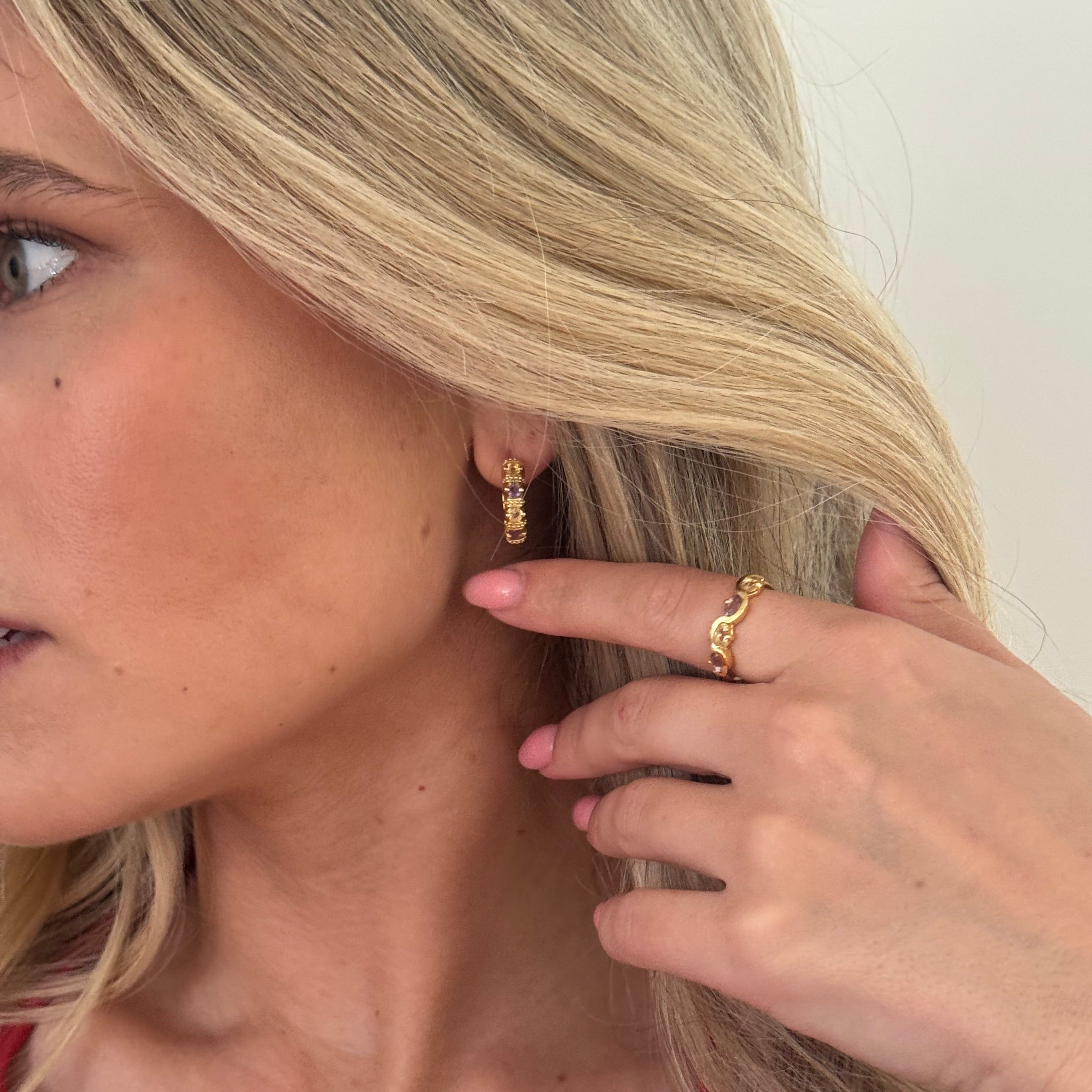 Close-up of a person with blonde hair and a gold ring on their finger.