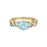Gold ring with blue gemstones on a white background