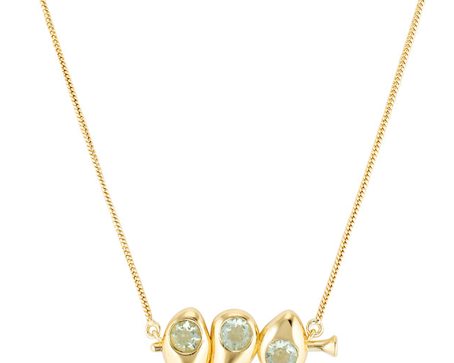 Gold necklace with three green gemstones on a white background