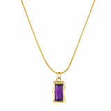Gold necklace with a purple gemstone pendant on a white background
