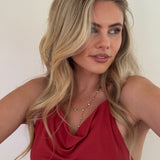 Woman wearing a red top with a plain background