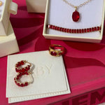 Flat lay of Bixby packaging and Two Broke chicks red gemstone jewellery 