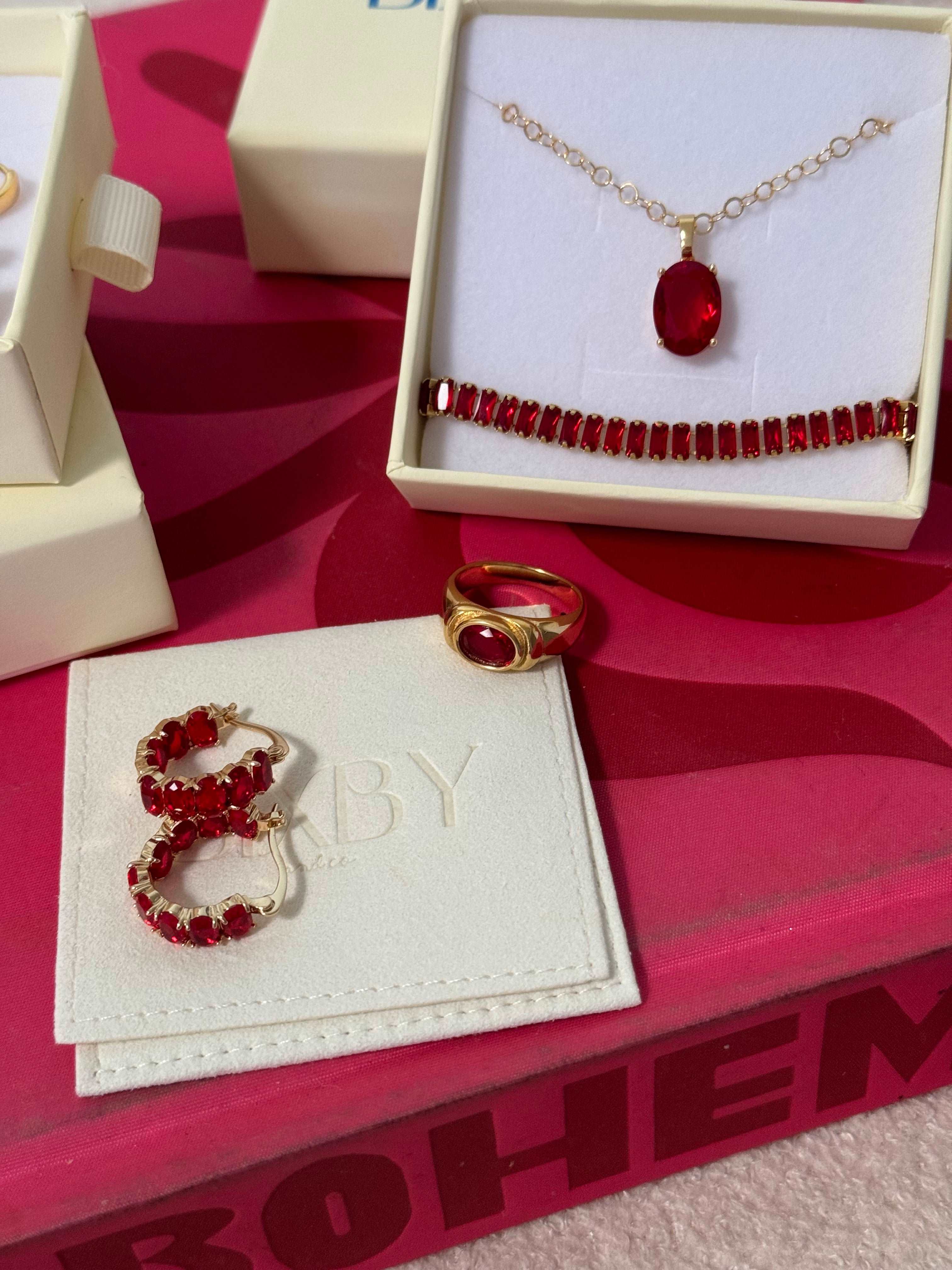 Flat lay of Bixby packaging and Two Broke chicks red gemstone jewellery 