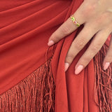 Close-up of a hand wearing a ring on a red fabric background