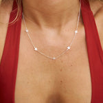 Close-up of a woman wearing a silver star necklace with a red top.