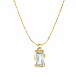 Gold necklace with a rectangular pendant on a white background