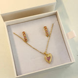 Gold heart-shaped necklace and earrings set in a box