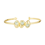 Gold bracelet with three green gemstones on a white background