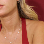 Close-up of a person wearing a star-shaped necklace and earring against a red background