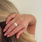 Hand with a silver ring on a blurred background