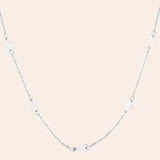 Silver necklace with star-shaped pendants on a white background
