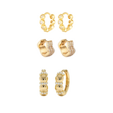 Set of gold hoop earrings with small diamonds on a white background