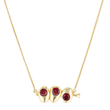 Gold necklace with three red gemstones on a white background