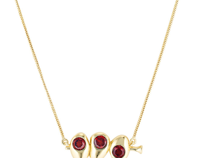 Gold necklace with three red gemstones on a white background