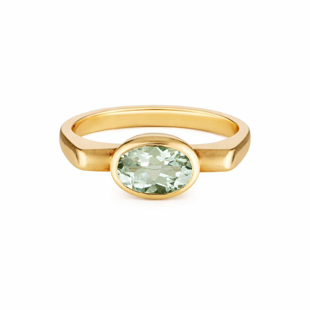 Gold ring with a green gemstone on a white background