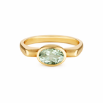 Gold ring with a green gemstone on a white background