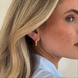 Close-up of a woman with long, wavy hair on a light background