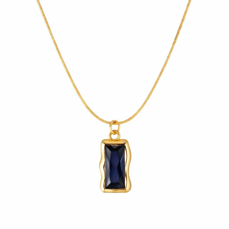Gold necklace with a blue gemstone pendant on a white background