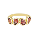 Gold ring with four red gemstones on a white background