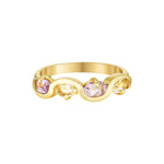 Gold ring with pink gemstones on a white background