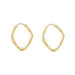 A pair of gold abstract wavy hoop earrings on a light gray background.