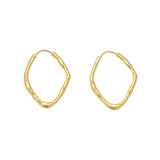 A pair of gold abstract wavy hoop earrings on a light gray background.