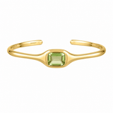 A gold open cuff bracelet featuring a central square-cut light green gemstone, with the brand name 'BIXBY' engraved on the inside, shown against a plain white background.