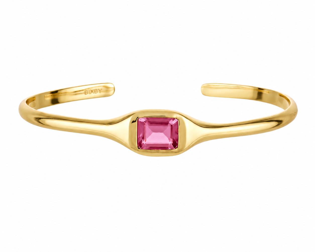 A gold open cuff ring featuring a central square-cut pink gemstone, shown on a plain white background.