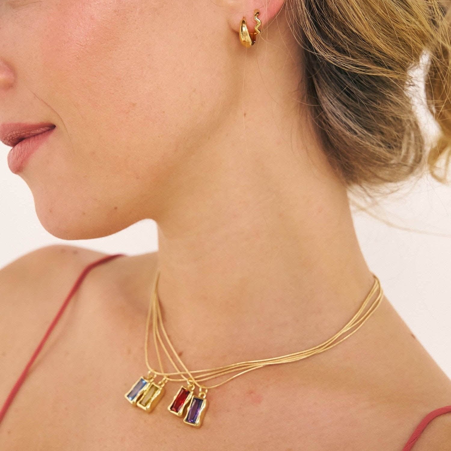 Model in coloured birthstone necklaces