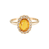Gold ring with a yellow gemstone on a white background