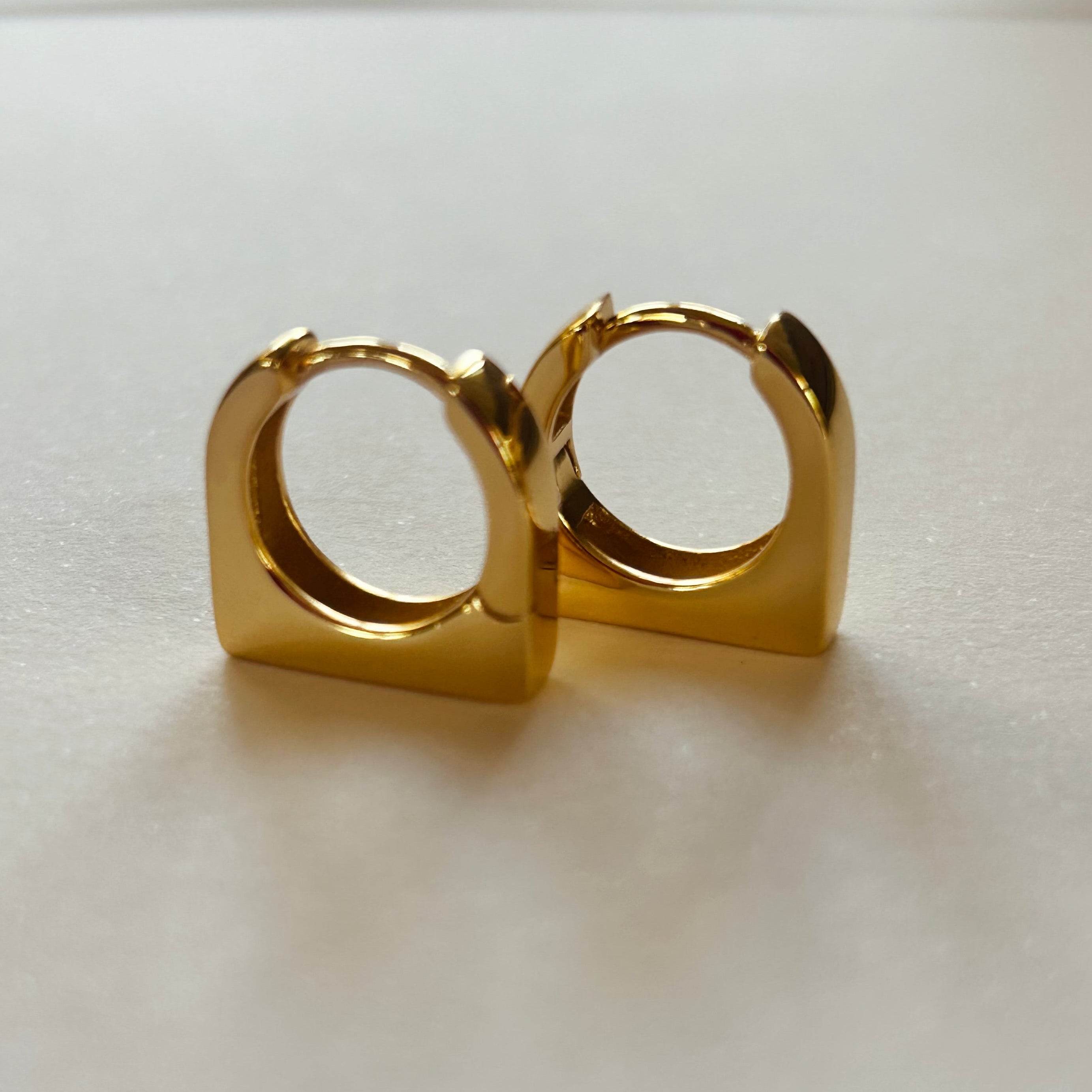 Pair of gold hoop earrings on a light background