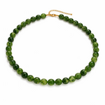 Green beaded necklace on a white background