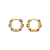 A pair of gold huggie hoop earrings decorated with small colorful gemstones, including purple, blue, green, and red, set against a plain white background.