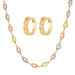 Jewelry set with gold hoop earrings and necklace featuring multicolored gemstones on a white background