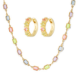 Jewelry set with gold hoop earrings and necklace featuring multicolored gemstones on a white background