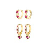 Gold hoop earrings with pink heart-shaped stones on a white background