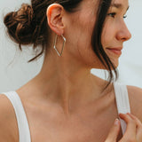 Woman wearing a white tank top with a blurred background