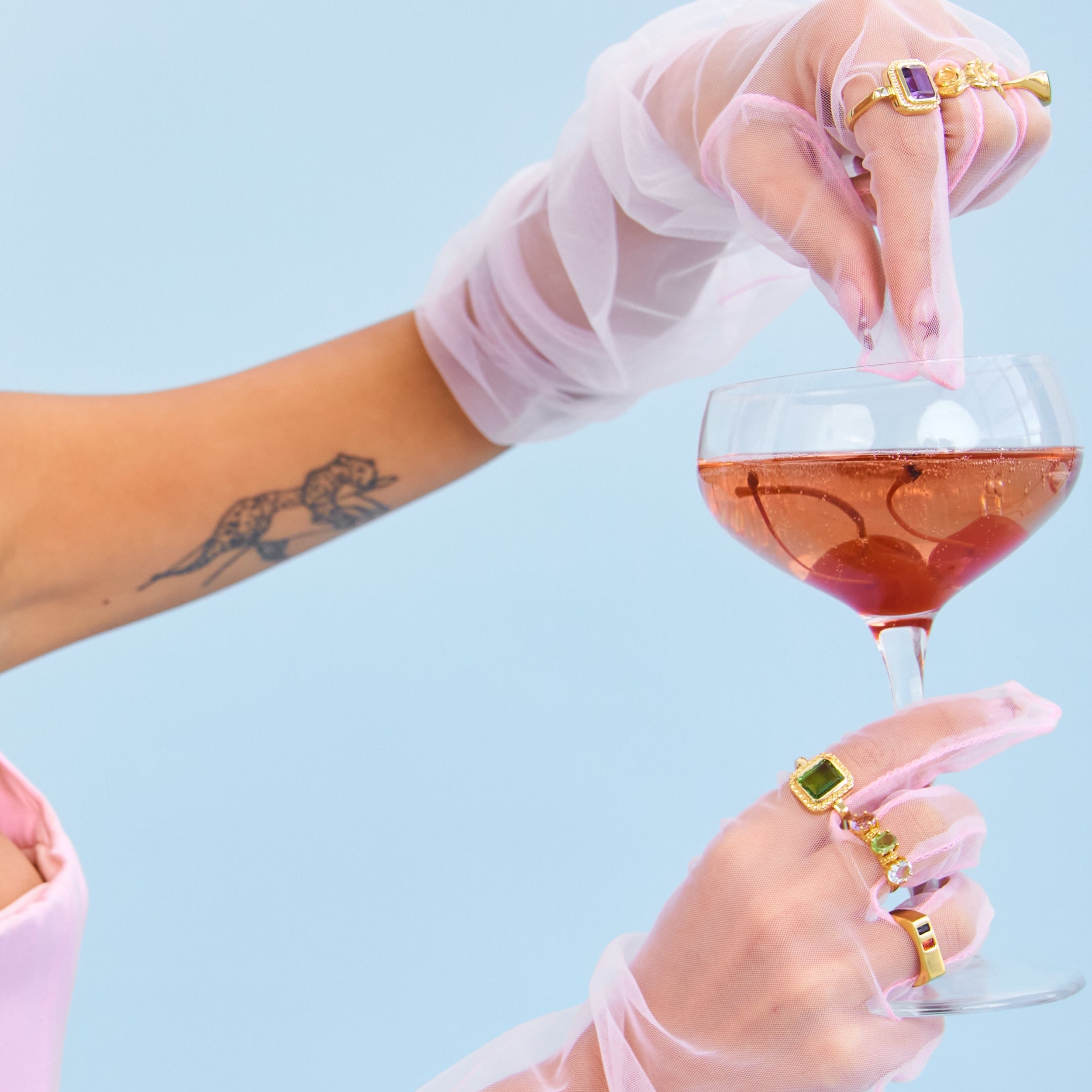 Woman holding a glass of pink wine against a light blue background