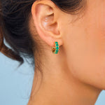Model wearing green gemstone hoops 