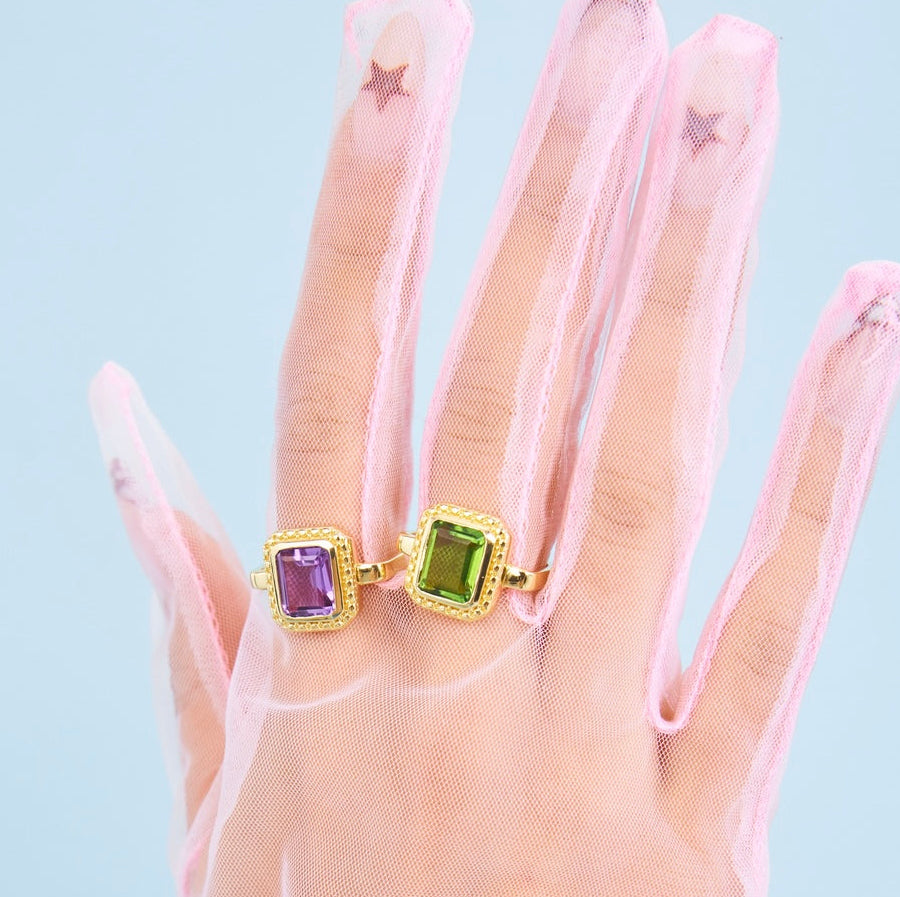 The two Dauphine cocktail rings in Amethyst and Peridot on a gloved hand 