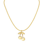 Gold necklace with a cherry pendant on a white background