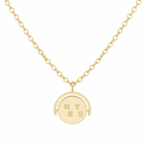 Gold necklace with a round pendant on a white background