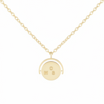 Gold necklace with a round pendant on a white background