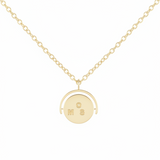 Gold necklace with a round pendant on a white background