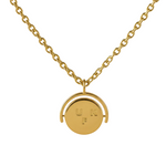 Gold necklace with a round pendant on a beige background