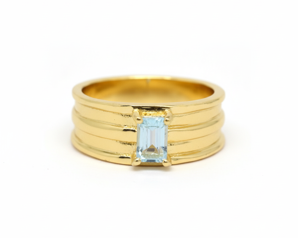 Gold ring with a rectangular blue gemstone on a white background