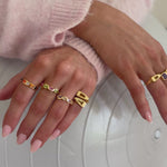 Model wearing multiple new gold rings 